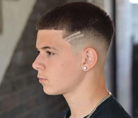 Close-up of a buzz cut with intricate patterns carved into the back of the head. 