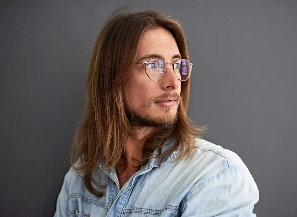 Man with long, layered hair flowing naturally for a relaxed bohemian look. 