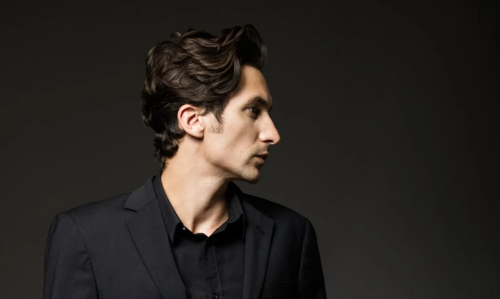 Men’s medium-length wavy hairstyle with natural texture and flow.