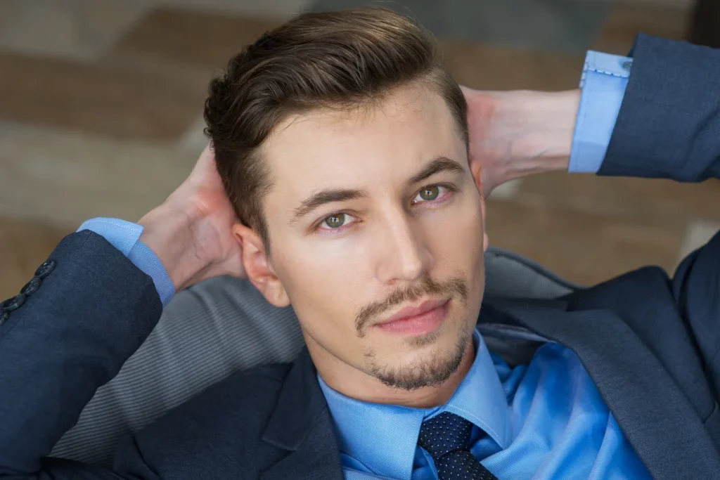 Man with an Ivy League haircut featuring a neatly combed top and tapered sides.