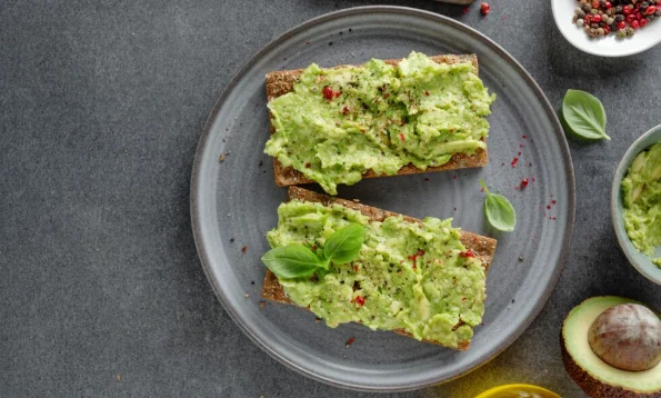 Tasty appetizing crispbread with mashed avocado served on plate