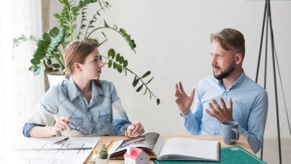 Two young colleagues discussing something at office-personal growth coach