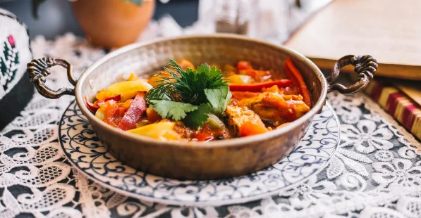 Copper pan with sauteed bell peppers and chicken garnished with herbs-crockpot recipes for two