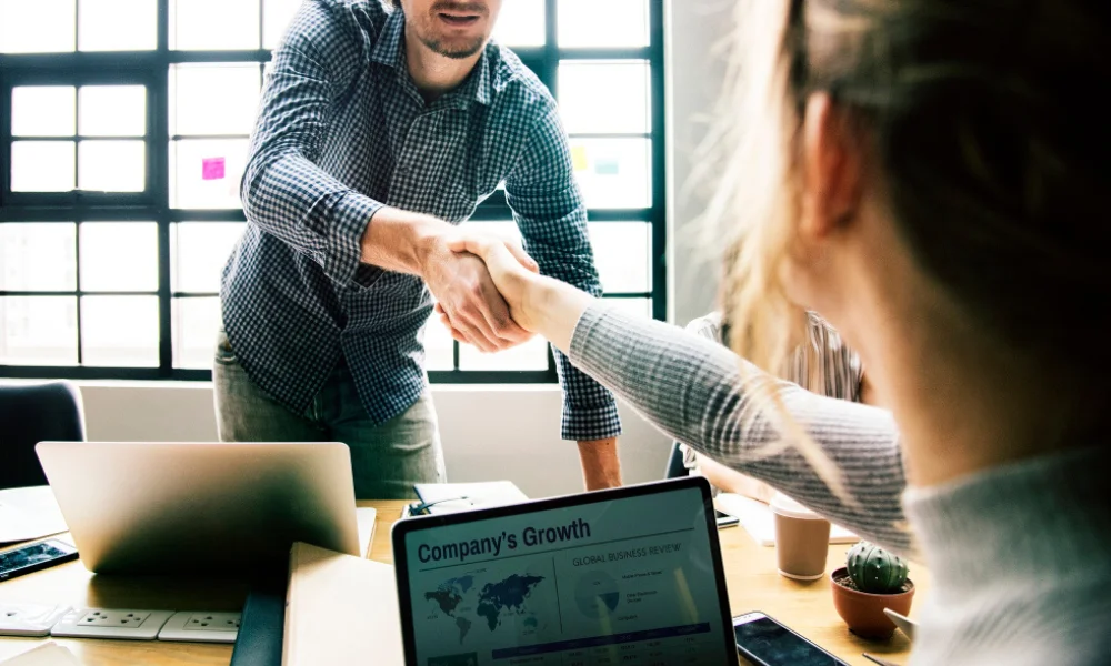 Business owner shaking hands with an SEO consultant to outsource website optimization tasks.