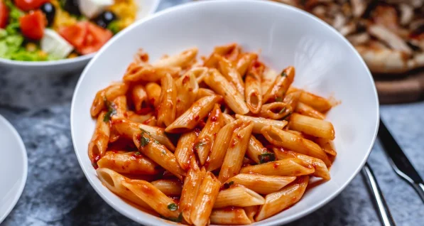 penne pasta with tomato sauce salt pepper and herbs on a plate-budget pasta dishes