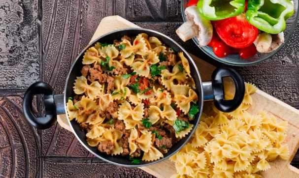 Pasta meal in pan with mushroom, pepper, tomato, raw pasta-cheap easy crock pot meals