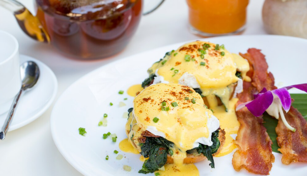 fresh egg benedict breakfast with black coffee and orange juice