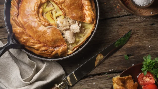 Pie on stainless steel bowl beside black handled knife