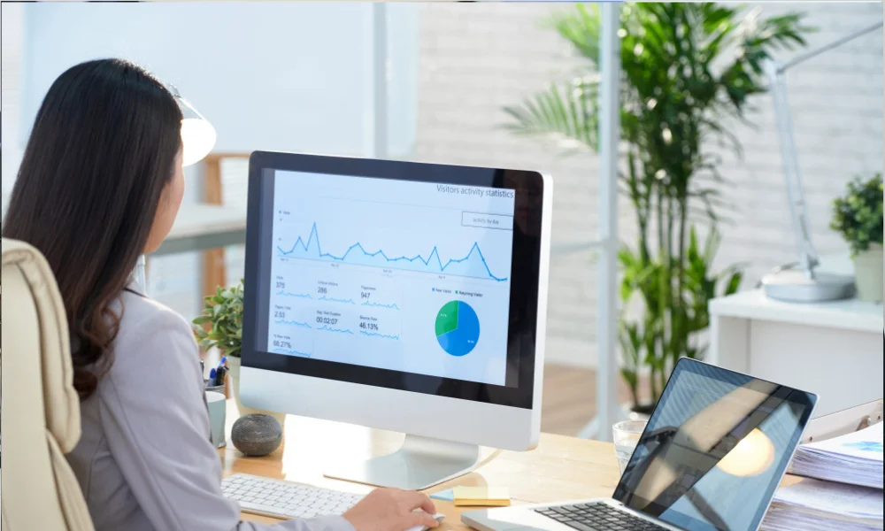 Marketer analyzing SEO performance graphs on a laptop.