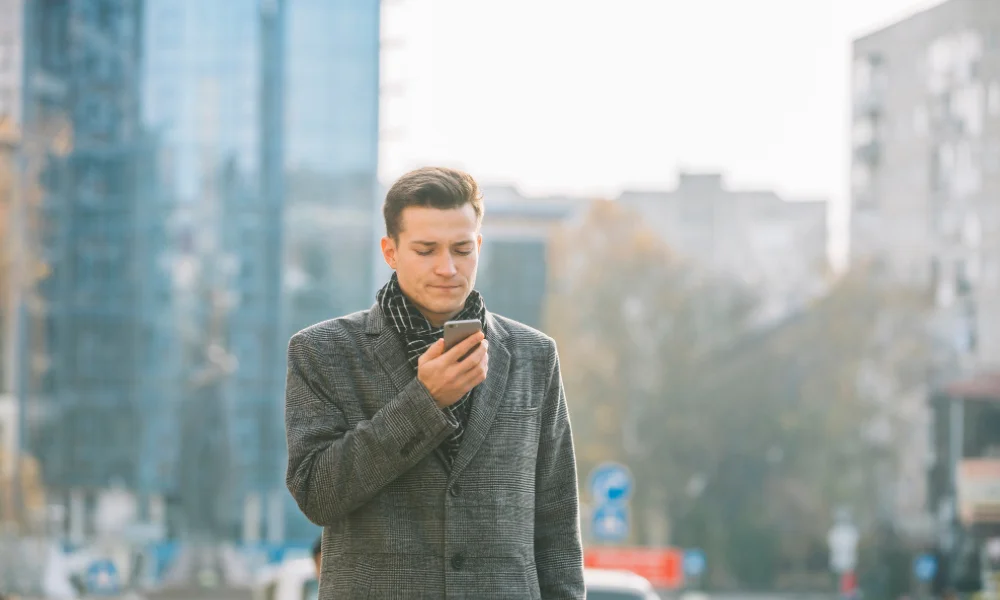 Person using voice search on smartphone while walking in city