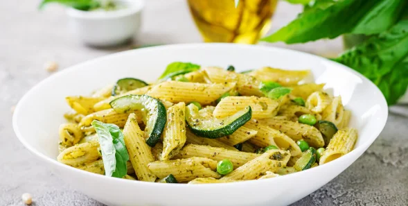 Penne pasta with pesto sauce, zucchini, green peas and basil. italian food-cheap pasta dishes