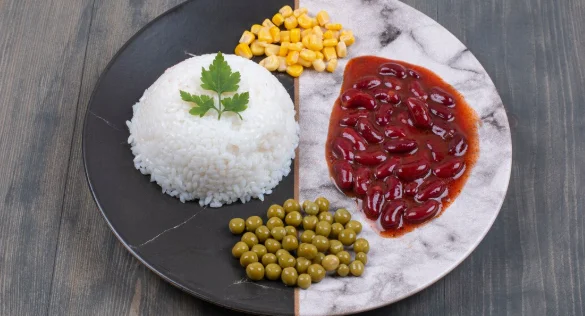 Steamed rice, canned corns and peas on plate-cheap vegetarian meal ideas