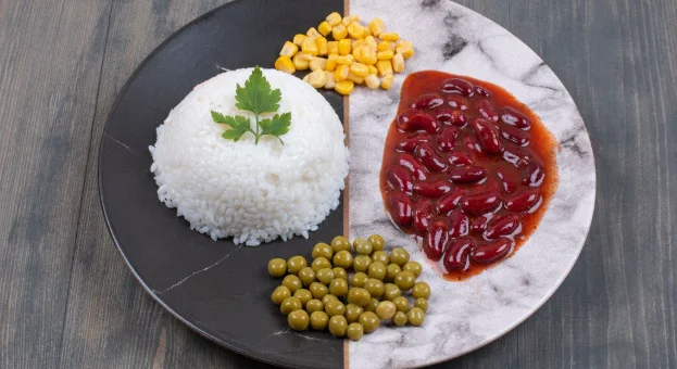 Steamed rice, canned corns and peas on plate