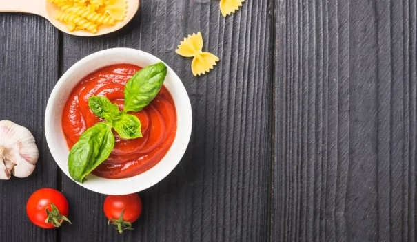 Top view of tomato sauce with garlic and pasta on wooden plank-inexpensive pasta recipes