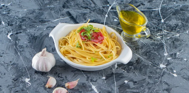 Delicious spaghetti on white plate with tomato sauce and olive oil.