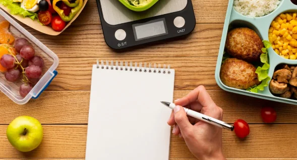 Top view tasty meal arrangement with empty notebook-crockpot meal prep