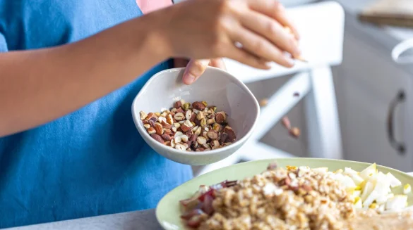 A woman prepares oatmeal with fruits closeup-cheap meatless recipes