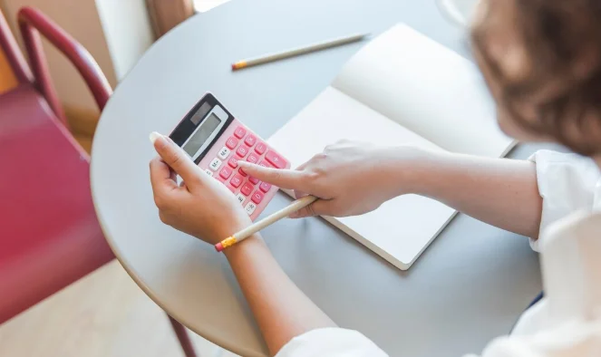Crop teen using calculator at table-Bills Calculator
