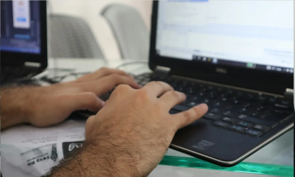 hands typing blog content on laptop