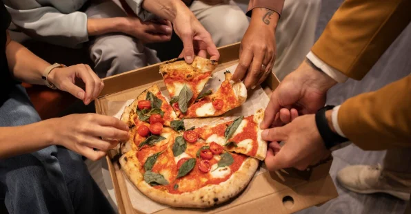 Close up hands holding pizza slices