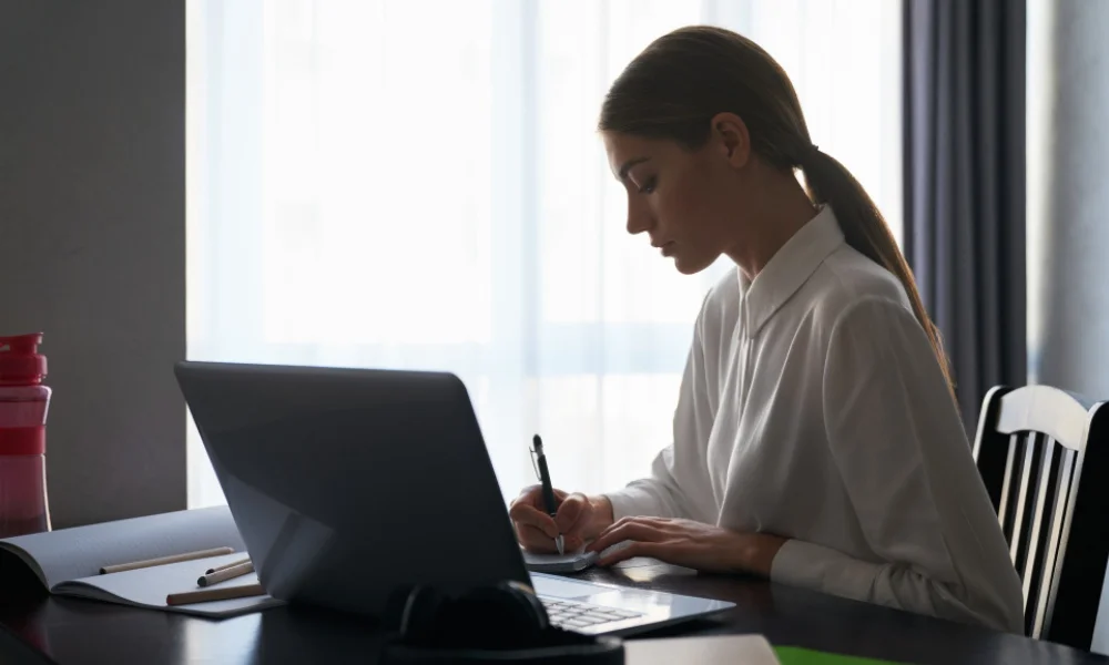 SEO content writer editing article for quality and keyword optimization on laptop.