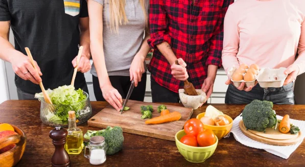 Mid section of friends preparing food in the kitchen-dinner ideas for family