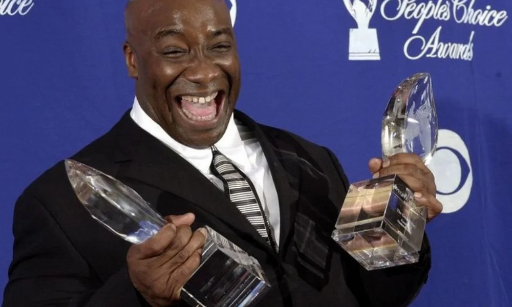 joyful man in a suit holds two crystal awards