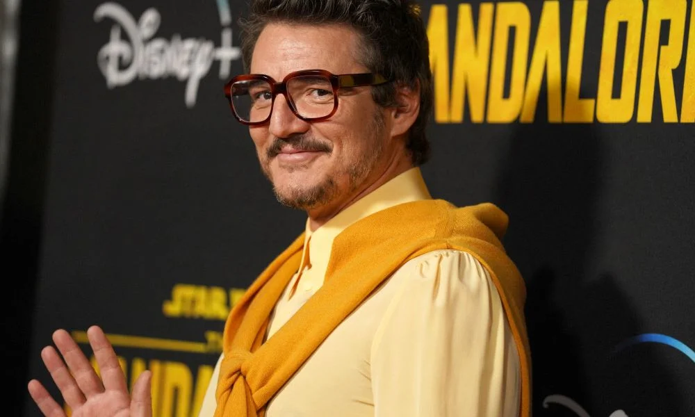 Pedro Pascal wearing glasses and a yellow outfit at a Disney+ event.