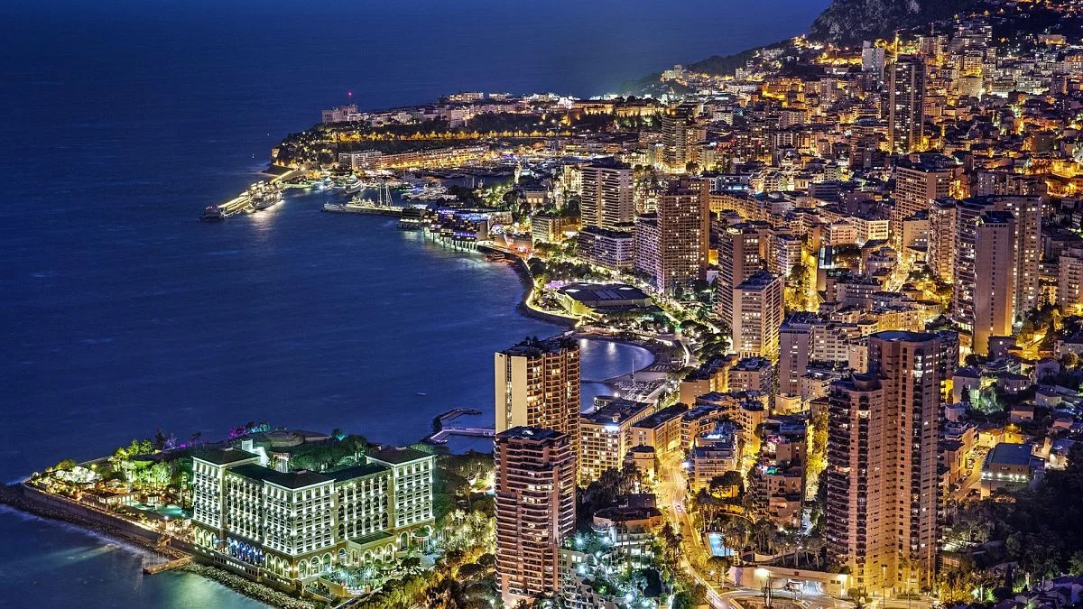 Nighttime aerial view of Monaco's brightly lit coastline-Best Luxury Travel Destinations