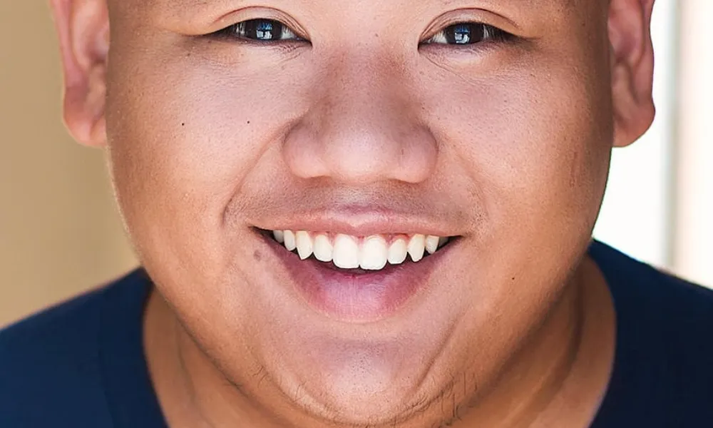 A studio portrait of Spider-Man star Jacob Batalon smiling at the camera, highlighting key acting milestones that contributed to the Jacob Batalon net worth.