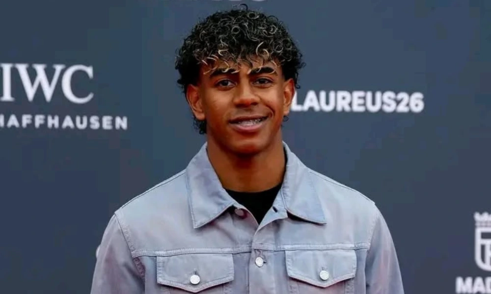 FC Barcelona star Lamine Yamal smiling on a red carpet wearing a light grey denim jacket at the Laureus World Sports Awards, ideal for content focusing on lamine yamal net worth.