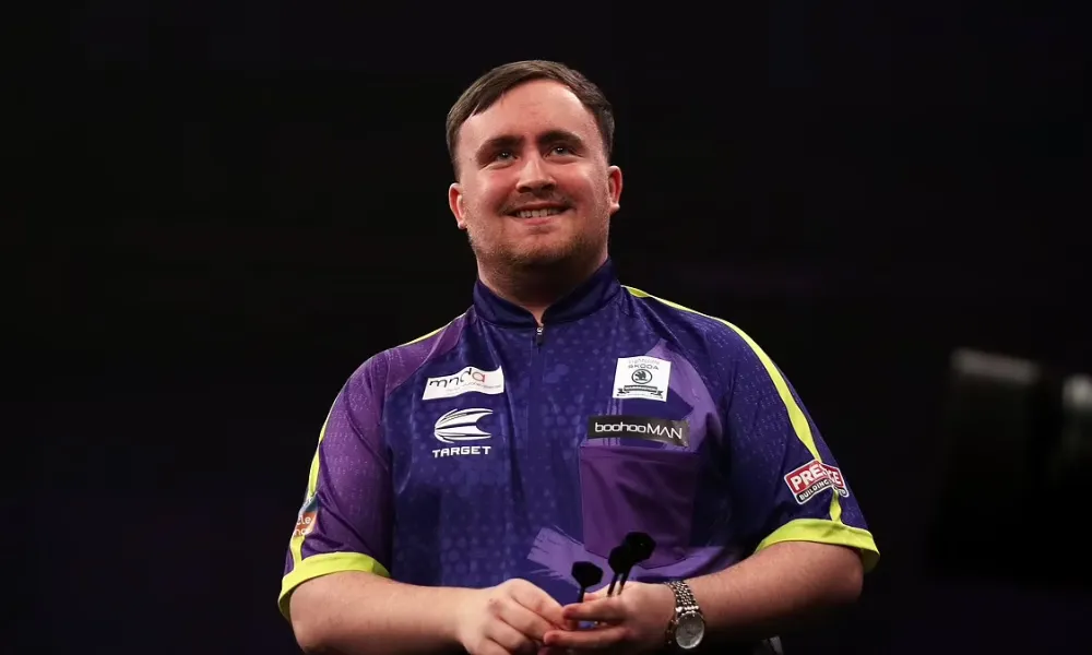  Professional darts player Luke Littler looks focused in a close-up portrait, representing the growing interest in Luke Littler net worth following his career success. 