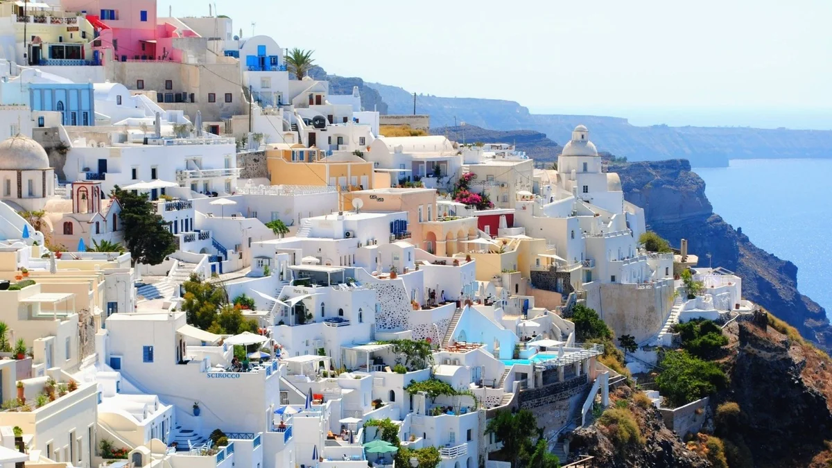 Whitewashed cliffside buildings and domes of Santorini overlooking the Aegean Sea.