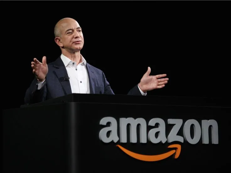 Jeff Bezos smiling in a suit at a public event, representing one of the world’s richest individuals in 2025.