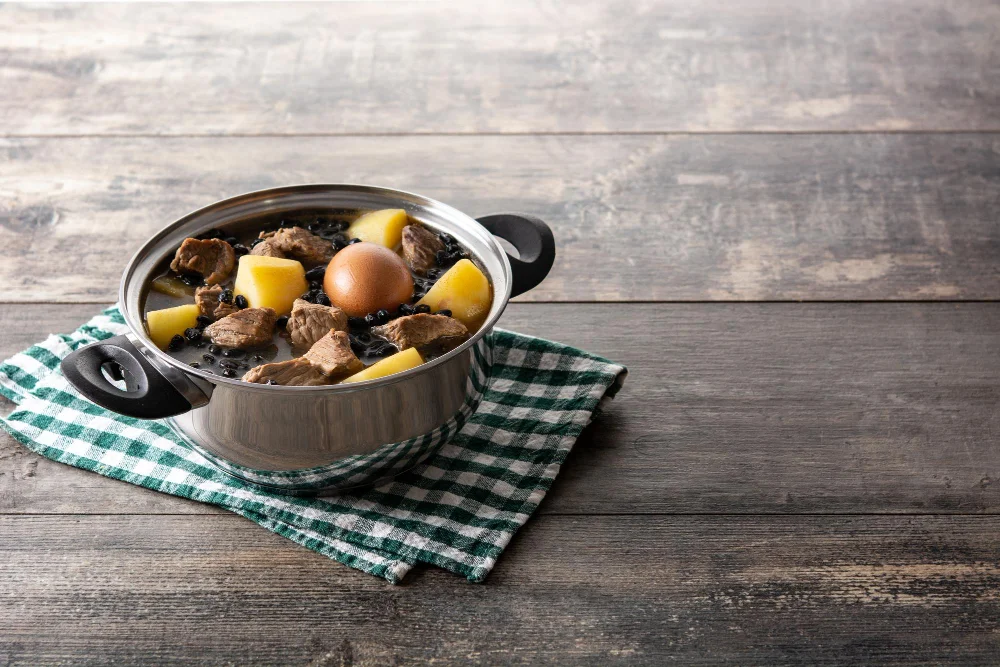 Traditional jewish cholent in casserole on wooden table