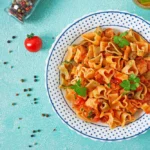 Pasta in the shape of hearts with chicken and tomatoes in tomato sauce