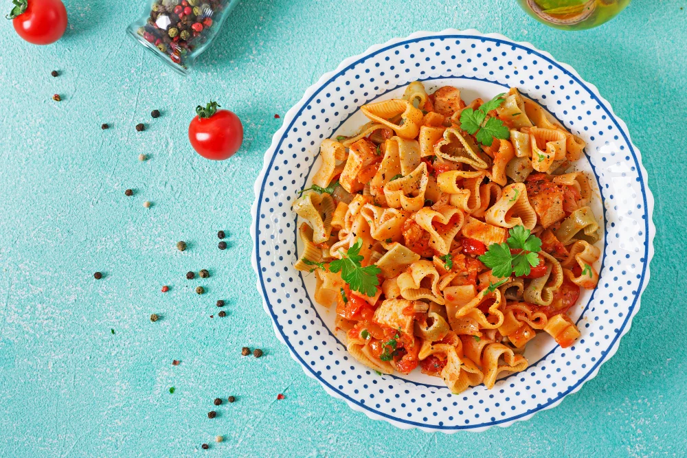Pasta in the shape of hearts with chicken and tomatoes in tomato sauce