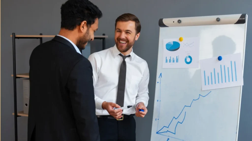 Business owner celebrating growth while SEO consultant shows improved ranking report