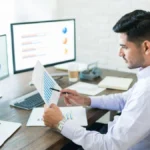 Business professional working on a laptop with SEO reports.