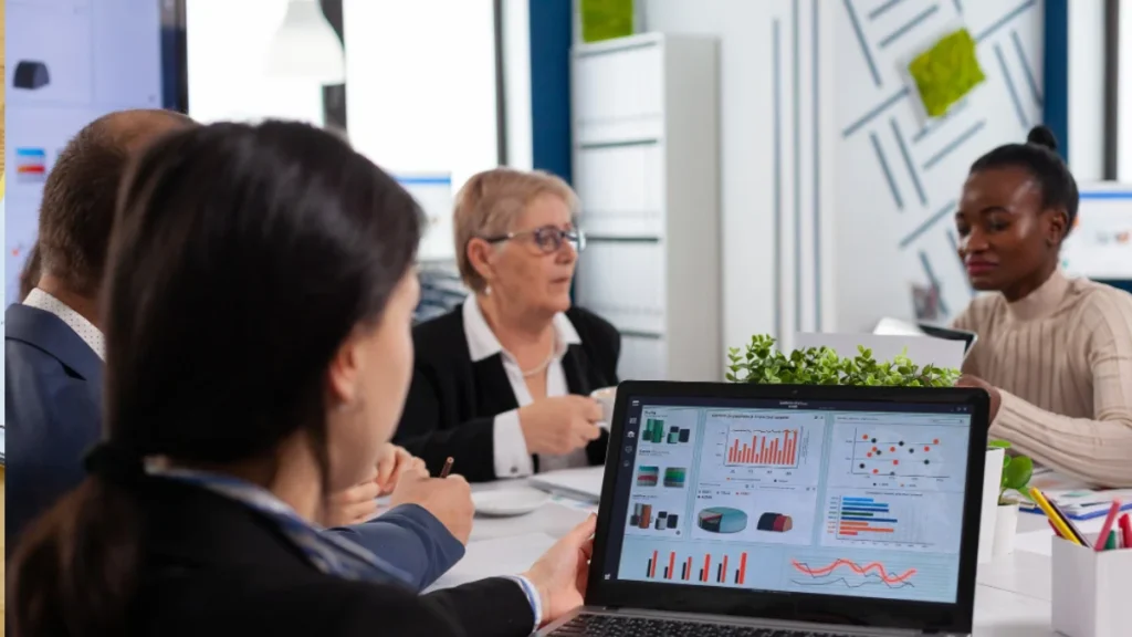 Business team analyzing SEO outsourcing strategies on laptops with digital reports.