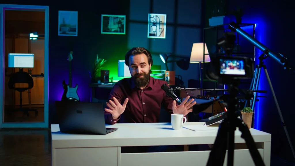 YouTuber recording video with camera, lights, and laptop open