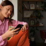 Young woman shopping online using TikTok Shop on her smartphone at home