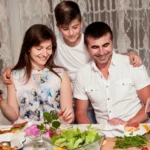 Front view of parents with son at dinner table