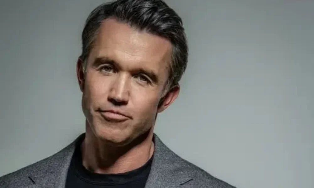 A portrait of American actor, writer, and producer Rob McElhenney against a neutral background, highlighting his career success and estimated Rob McElhenney Net Worth