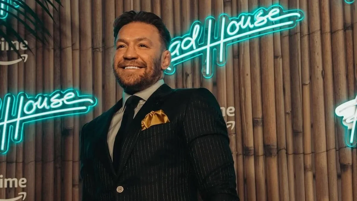 Conor McGregor posing in front of a Road House neon sign featuring Conor McGregor Net Worth