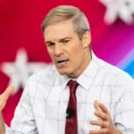 Jim Jordan wealth net worth 2026 highlights his career in politics, shown here with U.S. Representative Jim Jordan gesturing passionately during a speech in a white checkered shirt and red tie.