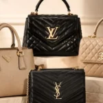 An assortment of high-end handbags from Prada, Louis Vuitton, Chanel, and Yves Saint Laurent arranged on marble stands, highlighting iconic fashion pieces to consider when evaluating are luxury brands worth investing in